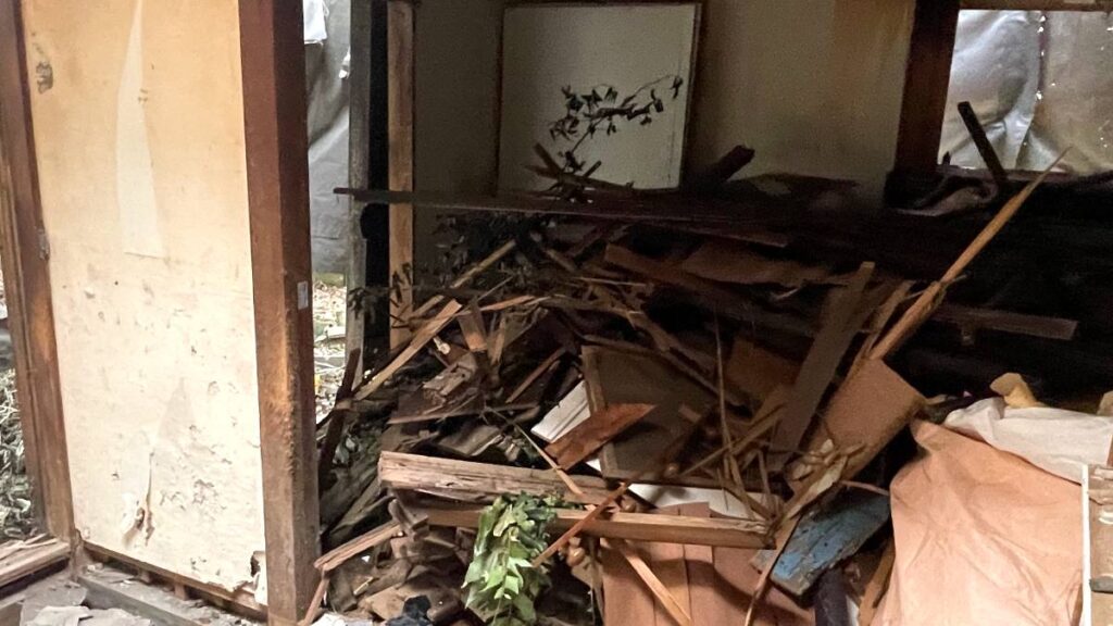 解体で崩れた壁材が積み上がった室内