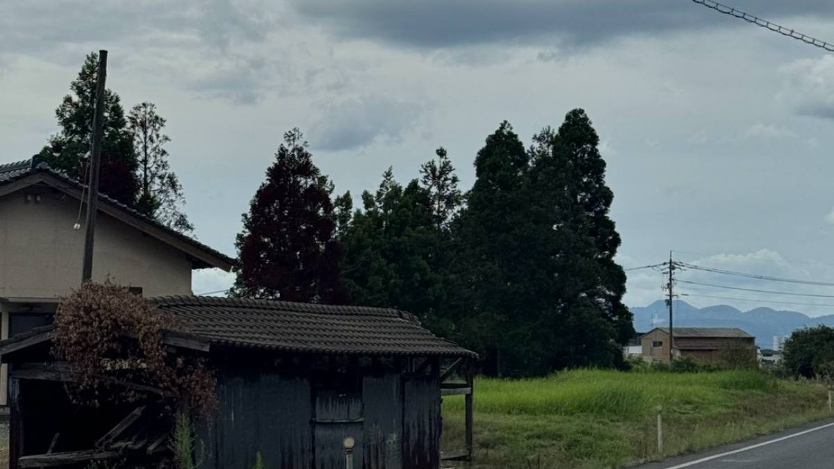 道路沿いに残る黒く煤けた板張りの納屋