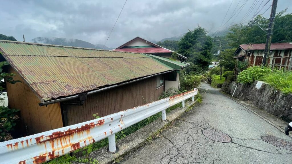山あいの集落に建つトタン屋根の家
