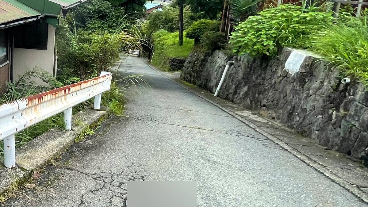 山あいの集落へ続く細い舗装路